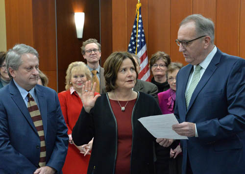 Vice Chair Harry Melander swearing in Slawik, who has her right hand raised.