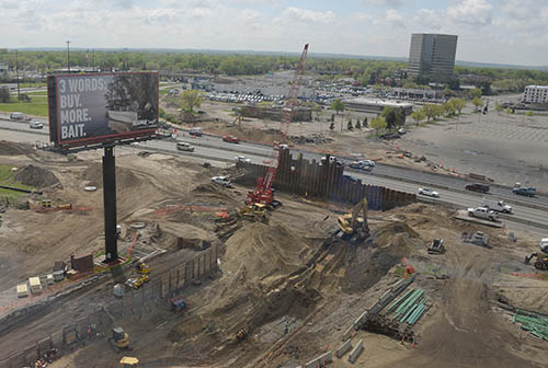 A large construction project next to a highway with vehicles.