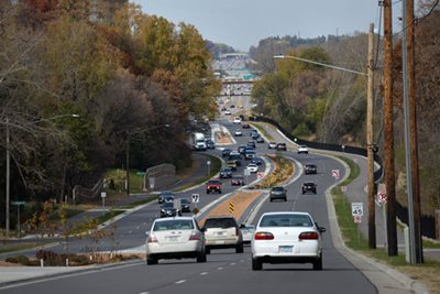 A four-lane road with a boulevard in the middle and walking path on the right.
