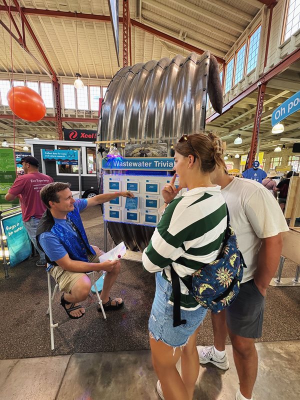 A couple ponders the answer to a question as a Met Council volunteer picks the next one.